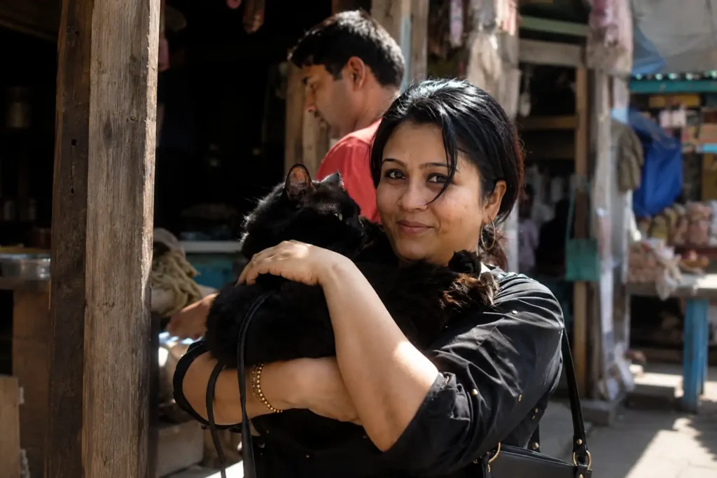 animal reiki articles 6 Tina Naik gently holding a relaxed black cat during a personalized Cat Reiki session focused on feline emotional wellbeing.